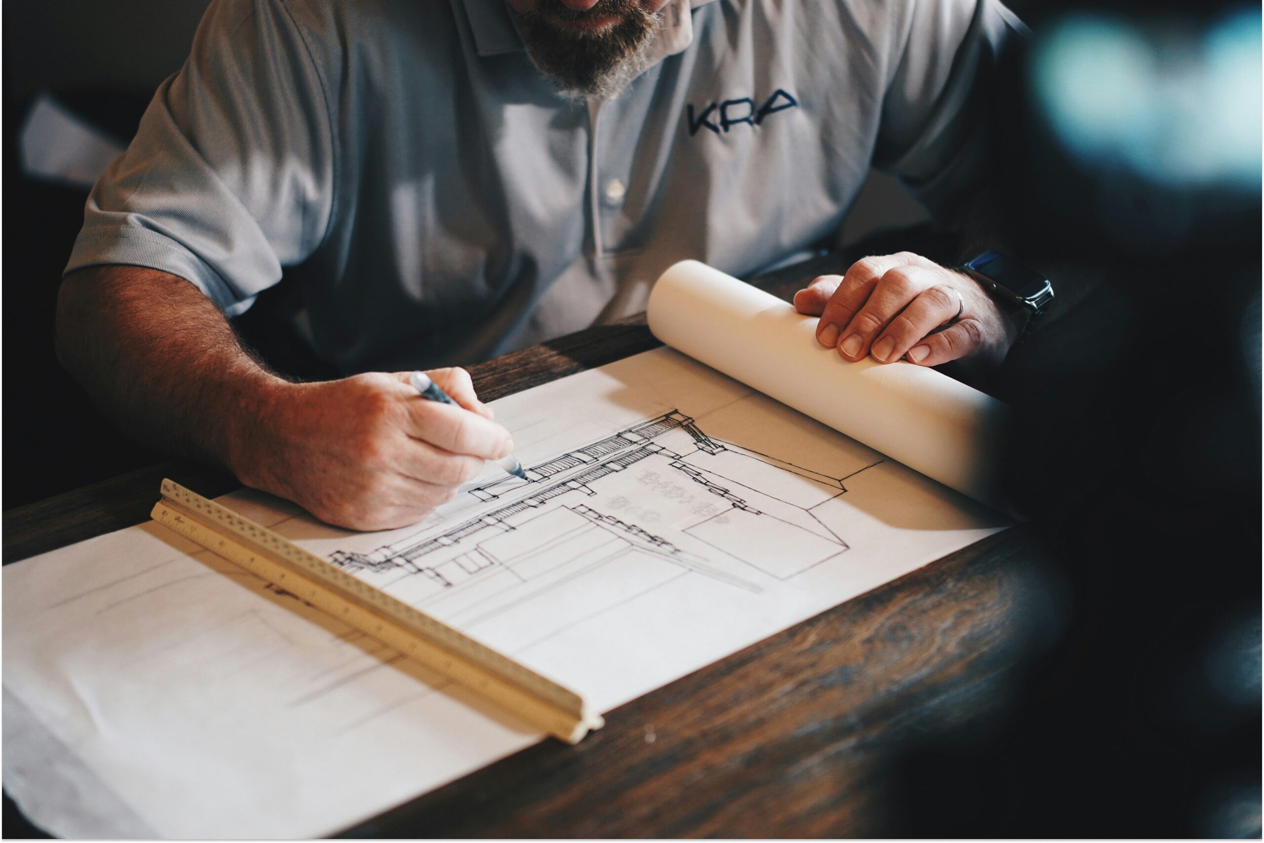 An architect working on a draft with a pencil and ruler.